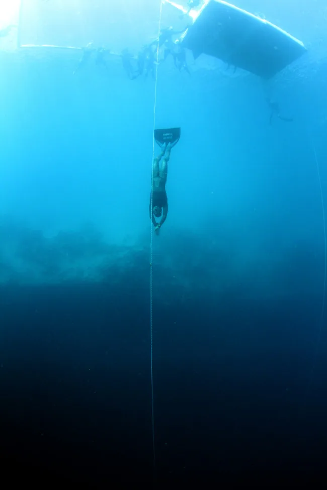 Freediver safety divers escorting a competitor on ascent