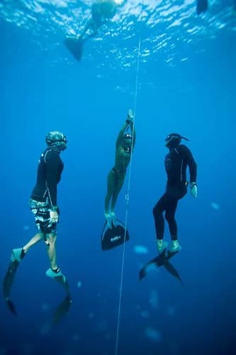 Freediver with safety divers during a constant weight dive