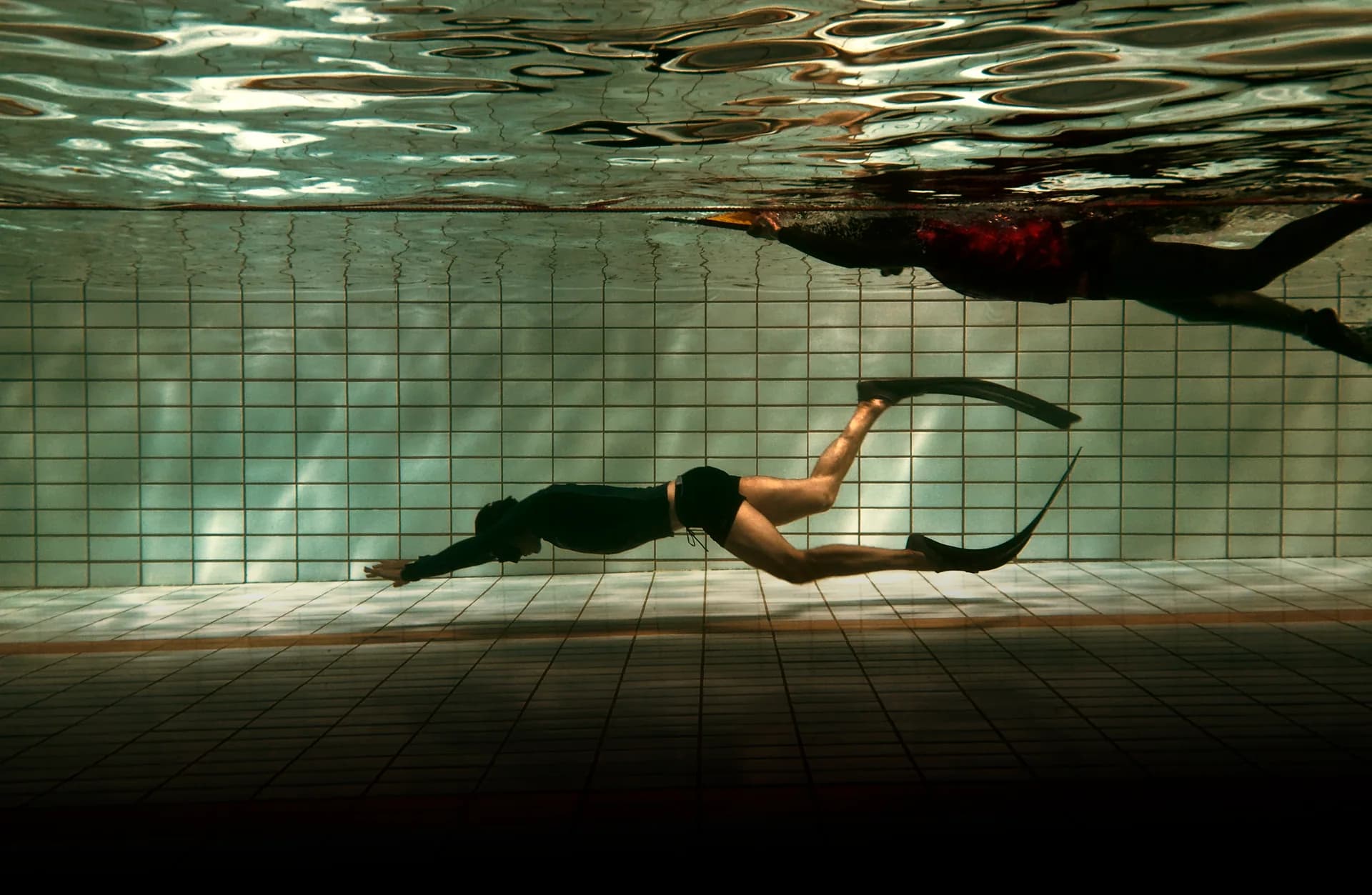 Freediver kicking off the surface to begin a depth dive