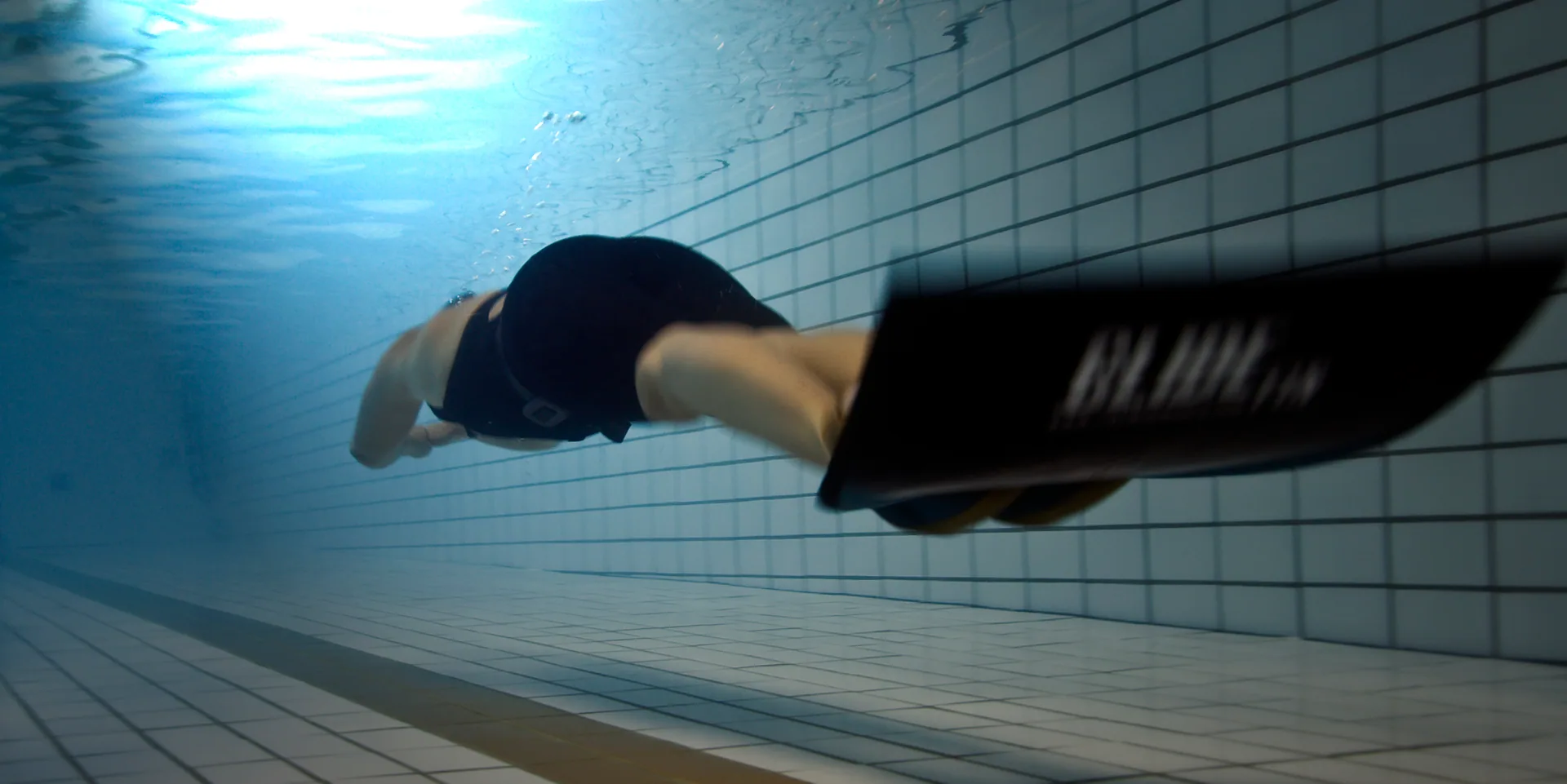 Freediver swimming with a carbon monofin underwater
